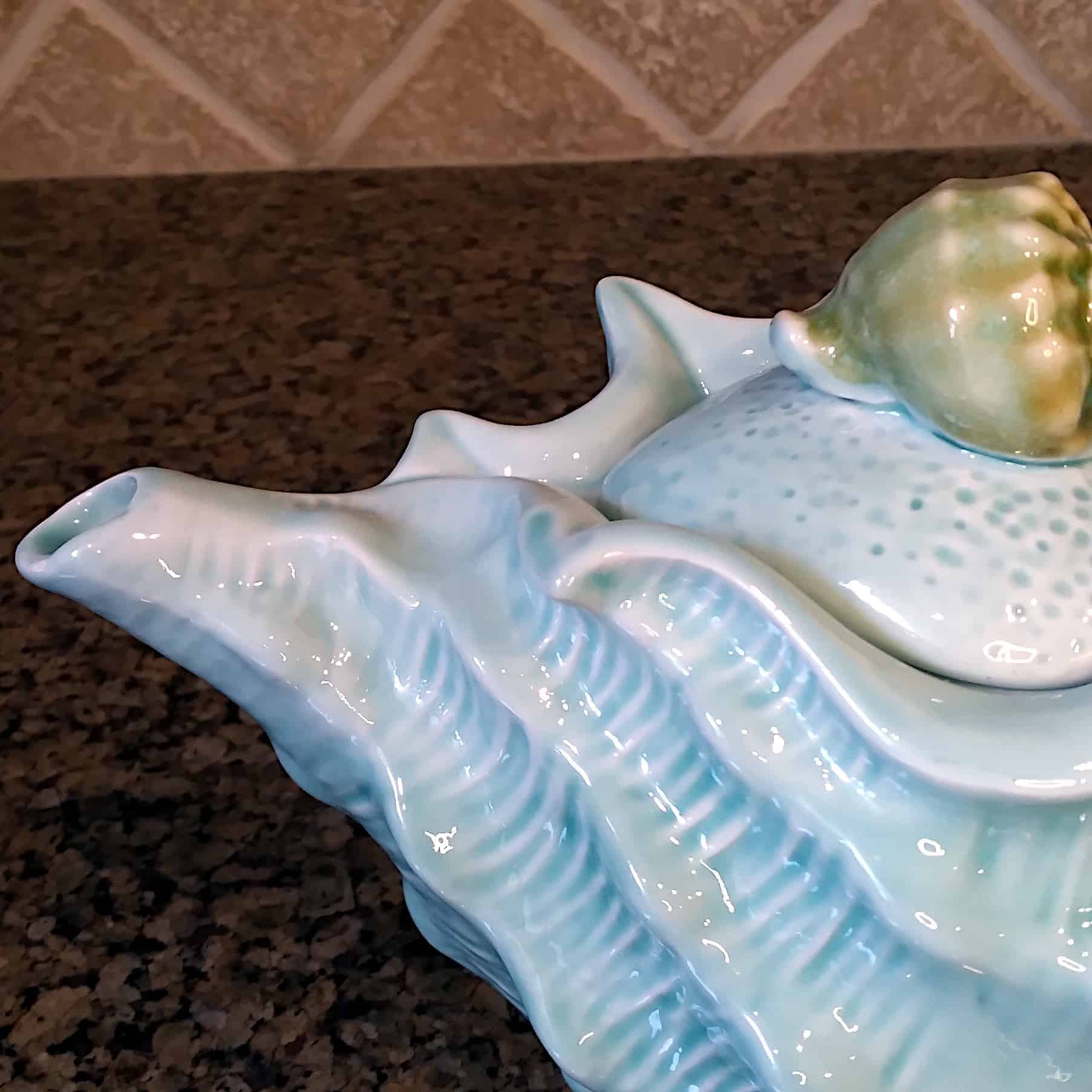 This Shell Teapot Blue Decorative Sea Life Home Decor by Blue Sky is made with love by Premier Homegoods! Shop more unique gift ideas today with Spots Initiatives, the best way to support creators.