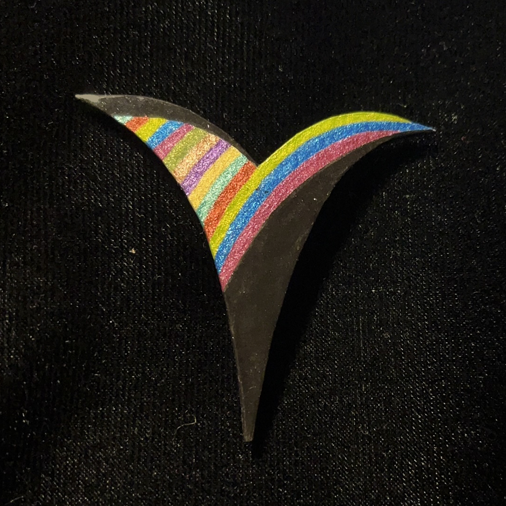 This Curvy V-Shaped Jewelry Art Brooch Black With Multi Color Metallic Accent Stripes is made with love by Premier Homegoods! Shop more unique gift ideas today with Spots Initiatives, the best way to support creators.