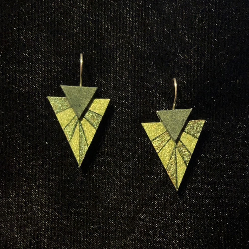 This Double Triangle Jewelry Art Earrings In Dark Green And Shades Of Metallic Green is made with love by Premier Homegoods! Shop more unique gift ideas today with Spots Initiatives, the best way to support creators.