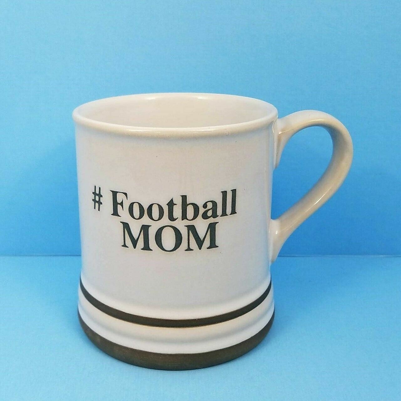 This Football Mom Coffee Mug Cup Pen Pencil Holder by Blue Sky Spectrum 17oz Hashtag is made with love by Premier Homegoods! Shop more unique gift ideas today with Spots Initiatives, the best way to support creators.