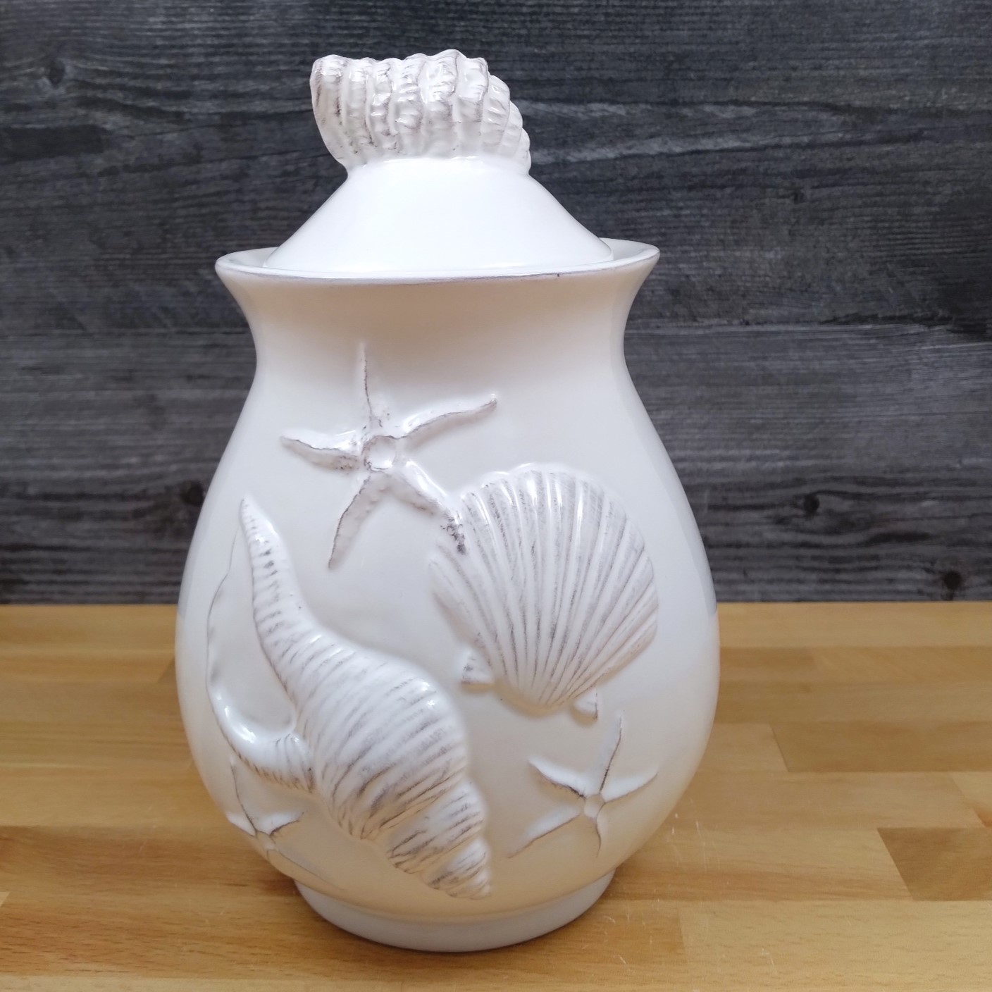 This Laguna Coastal Shell Canister 8" White Decorative Sea Life Jug by Blue Sky is made with love by Premier Homegoods! Shop more unique gift ideas today with Spots Initiatives, the best way to support creators.