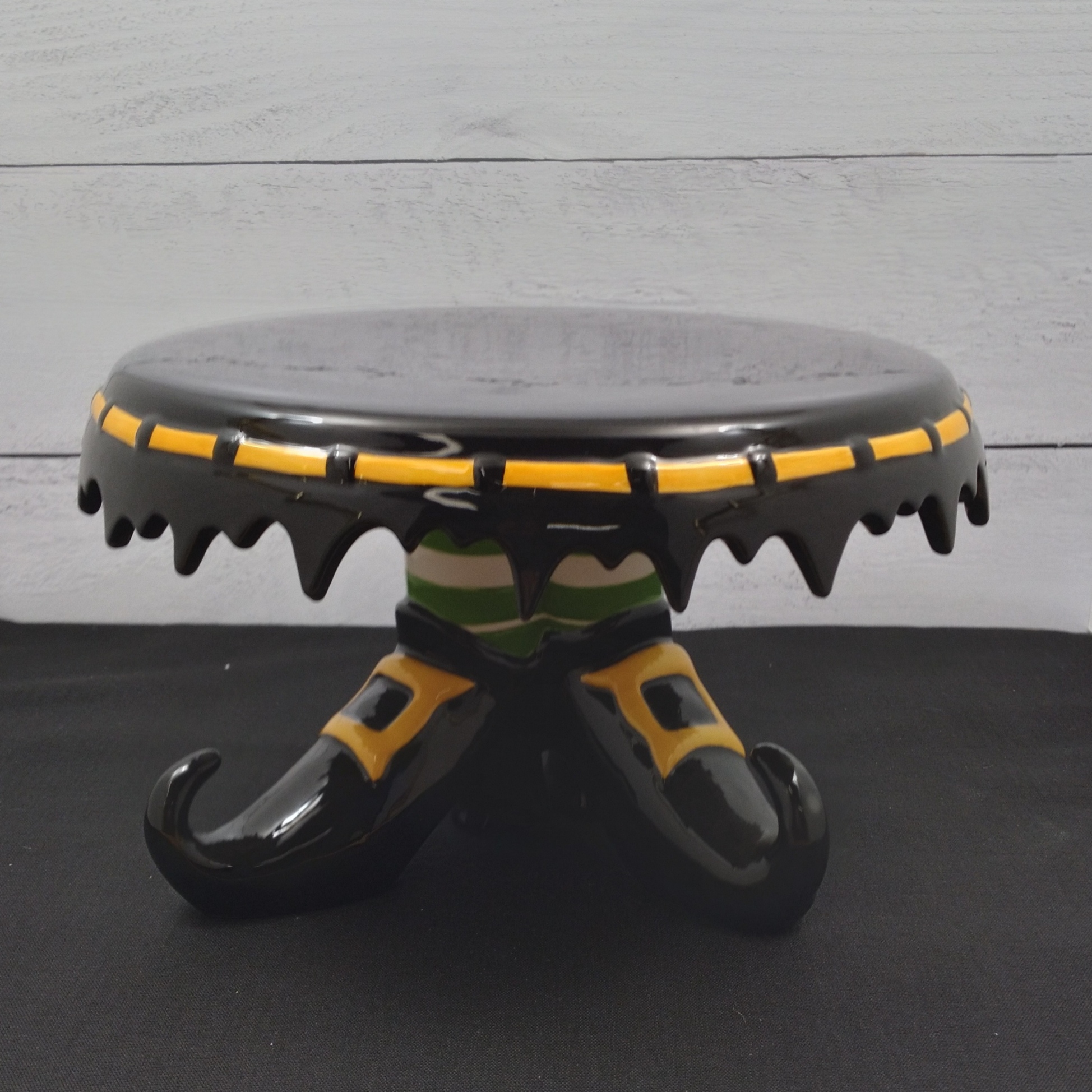 This Halloween Witch Feet Cake Stand by Blue Sky Clayworks and Heather Goldminic is made with love by Premier Homegoods! Shop more unique gift ideas today with Spots Initiatives, the best way to support creators.