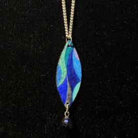 This Marquis Shaped Pendant Jewelry Art In Shades Of Blue And Aqua With A Blue Bead is made with love by Premier Homegoods! Shop more unique gift ideas today with Spots Initiatives, the best way to support creators.